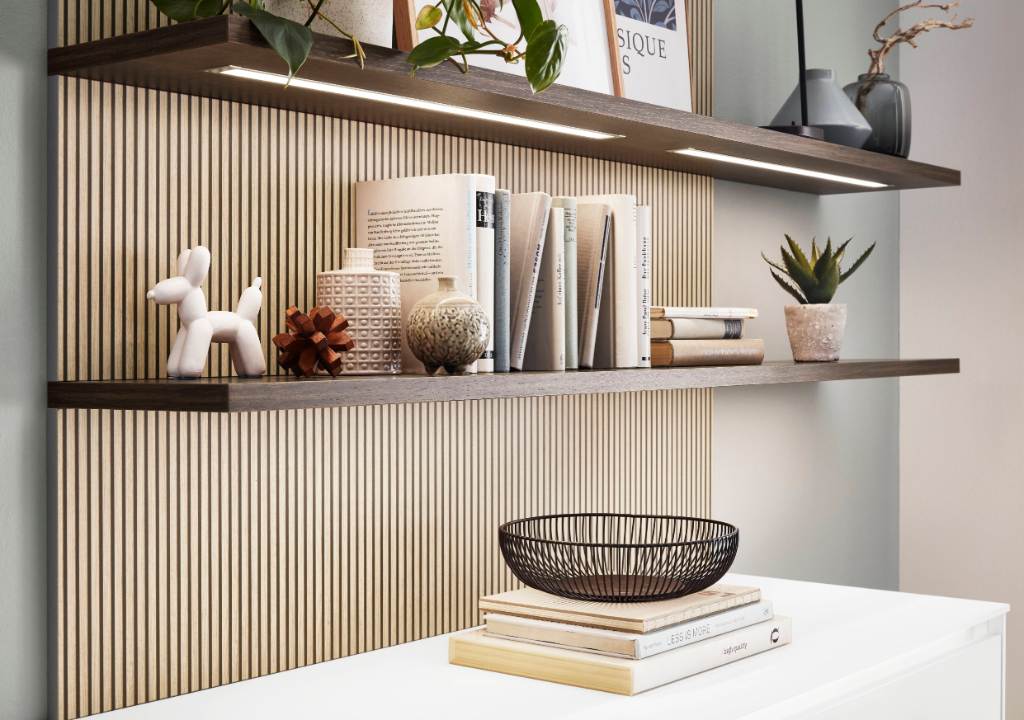 Estante iluminado sobre una pared de listones de madera con objetos decorativos