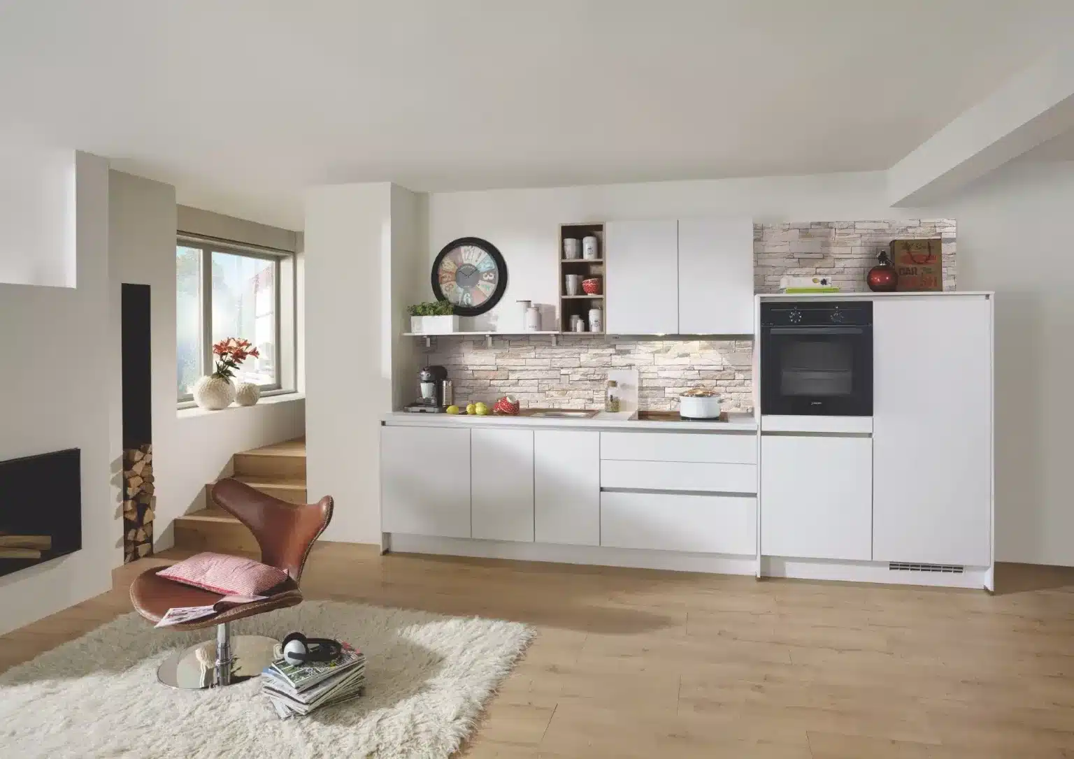 Cocina blanca lineal con horno integrado y revestimiento de piedra