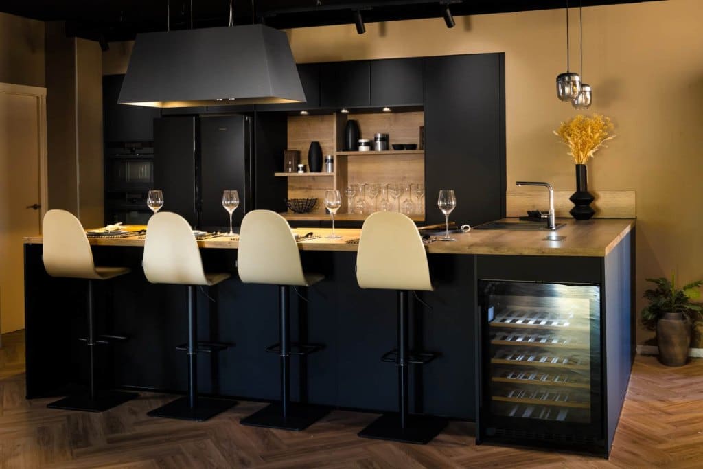 Cocina oscura con barra, taburetes y vinoteca integrada