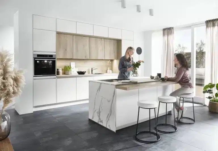 Dos personas junto a una isla de cocina blanca