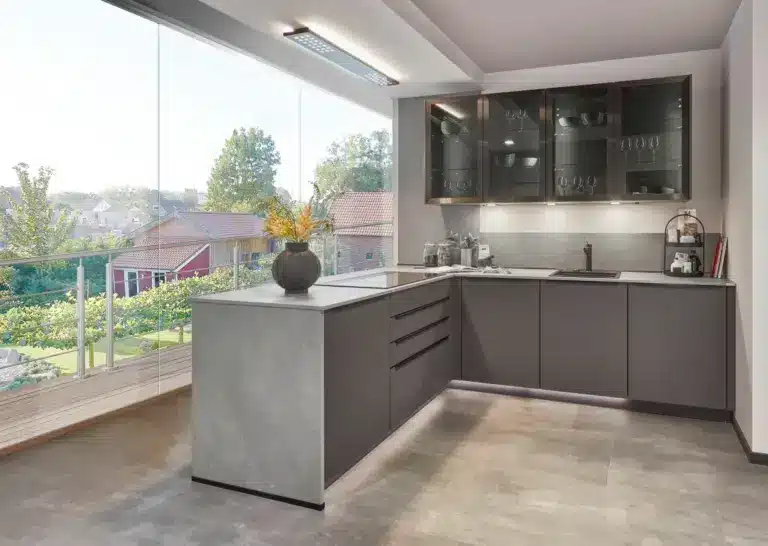 Cocina gris con península junto a grandes ventanas