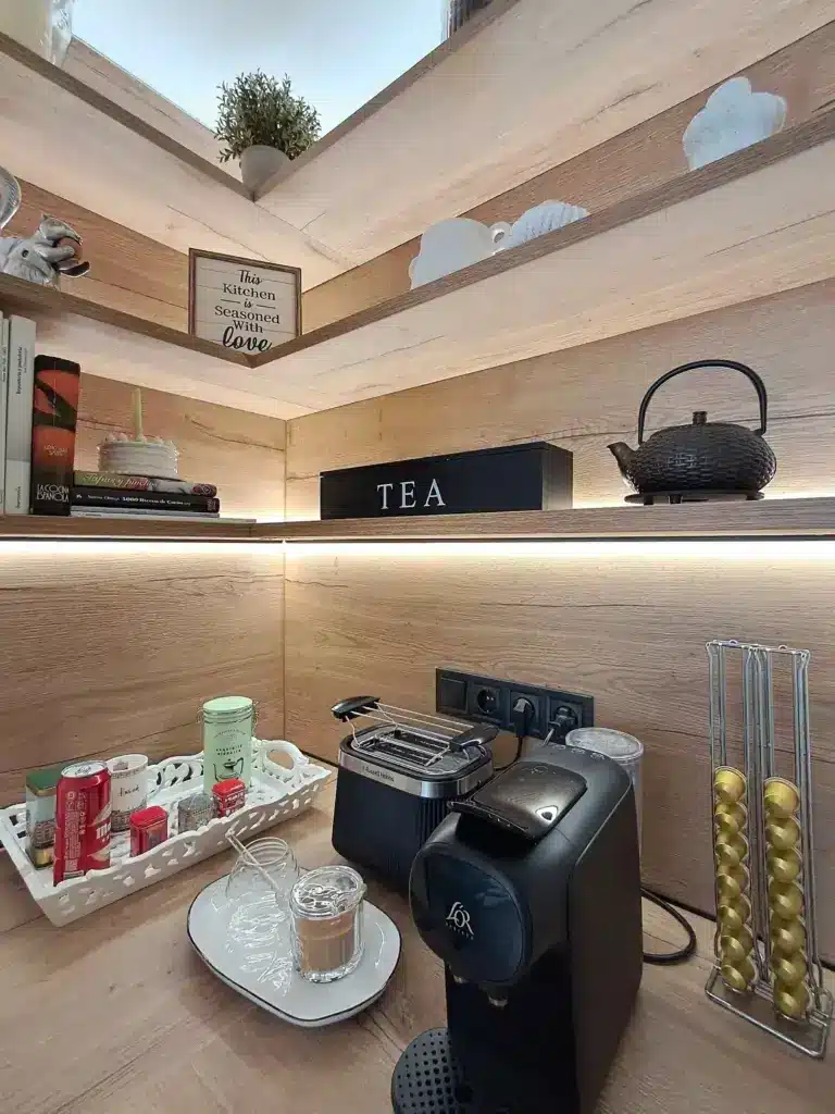 Rincón de café con estantes de madera y luz bajo el estante