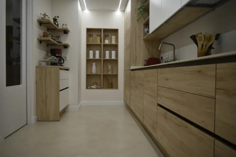 Cocina estrecha con muebles de madera y columna de horno